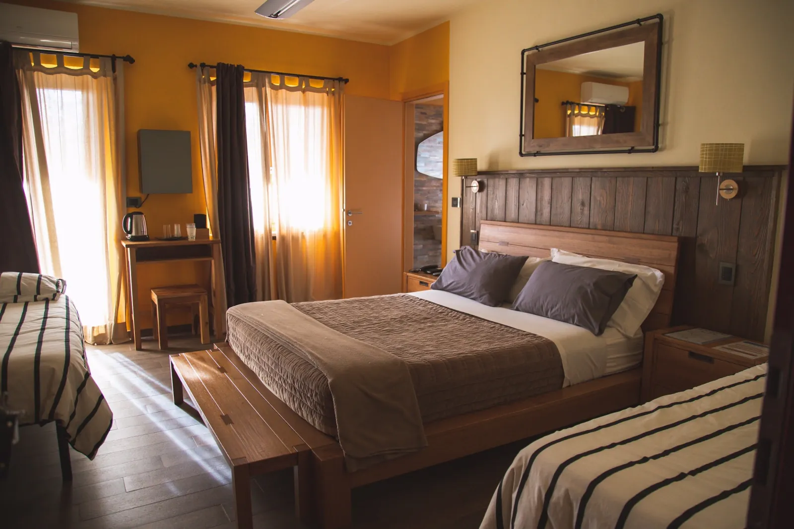 Letto matrimoniale e arredi in legno in una camera del Resort