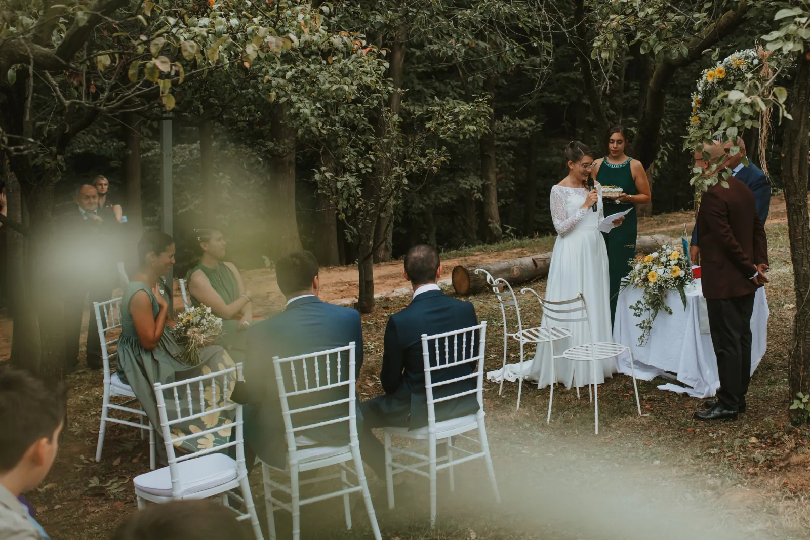 Gli sposi durante la cerimonia simbolica nel bosco, con gli invitati accanto